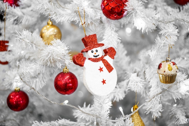 Decorazione bianca dell'albero di Natale con palline rosse su rami di abete