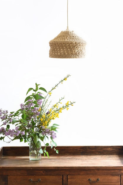 Decorazione d'interni minimalista con mobili in legno lampada e fiori di campo