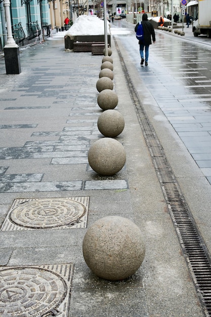 Decorazione del marciapiede della strada della città Sfere di pietra sul lato della strada