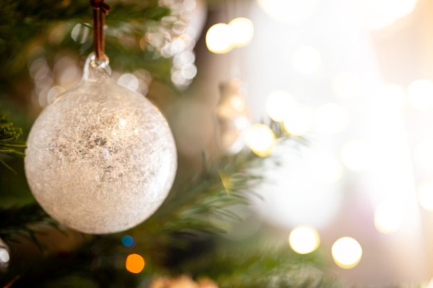 Decorazione dell'albero di Natale con palline bianche decorative e luci di Natale sfocate