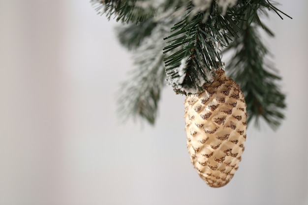 Decorazione dell'albero di Natale. Decorazione marrone del cono su un ramo dell'albero di Natale su un fondo confuso