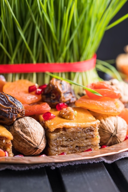 Decorazione della tavola di Novruz, erba di grano, pakhlava di pasticceria nazionale dell'Azerbaigian, celebrazione del nuovo anno, risveglio della natura