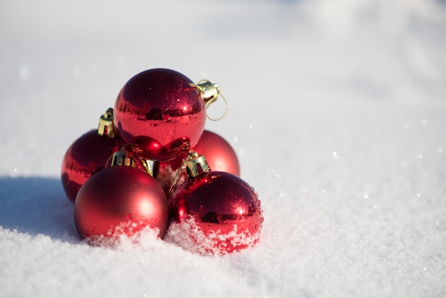 decorazione delle palle rosse di natale nella priorità bassa della neve fresca sulla bella giornata invernale di sole