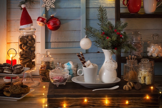 Decorazione di cacao di Natale bar con biscotti e dolci su fondo di legno blu in stile vintage