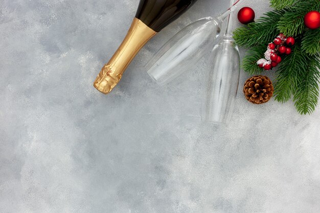 Decorazione di Capodanno con una bottiglia di champagne e rami di abete