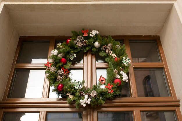 Decorazione di ghirlande di Natale su una porta di legno marrone con vetro