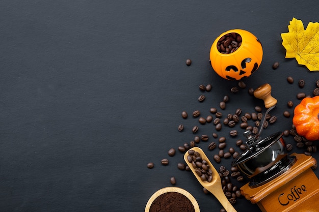 Decorazione di Halloween con caffè caldo e fagioli su sfondo scuro. laici piatta. Copia spazio per il testo.