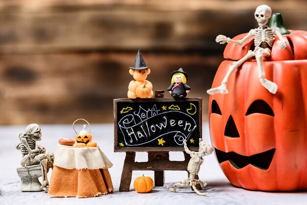 Decorazione di Halloween. Dolcetto o scherzetto in autunno e stagione autunnale. Faccia di zucca e simbolo spaventoso su uno sfondo di legno.