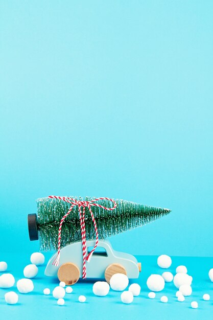 Decorazione di Natale con auto in legno, albero di pino, con spazio di copia. Biglietto di auguri di stagione