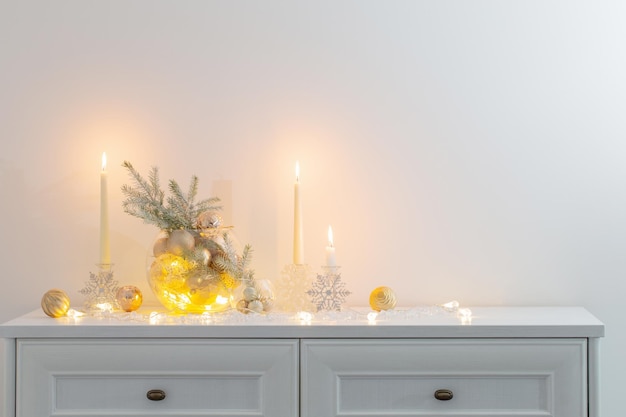 Decorazione di Natale con candele accese in interni bianchi