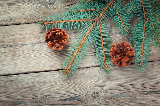 Decorazione di Natale con l&#39;albero di abete e pigne su fondo di legno bianco