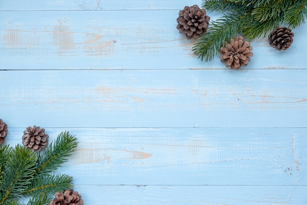 Decorazione di Natale, contenitore di regalo e rami di pino su fondo di legno