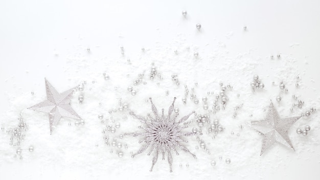 Decorazione di natale - stelle d'argento e fiocco di neve su priorità bassa bianca