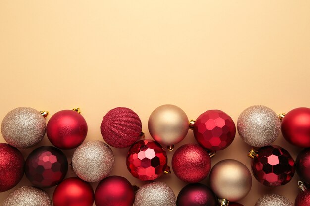 Decorazione di palline di Natale rosso e oro su sfondo beige con spazio per le copie. Biglietto di auguri di Capodanno. Stile minimale. Disposizione piatta.