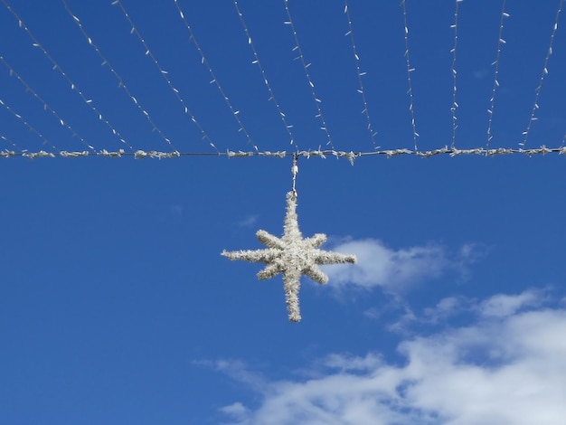 Decorazione di strada di Natale a forma di fiocco di neve contro il cielo blu