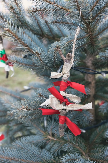 Decorazione fai-da-te fatta a mano con bastone e nastro sull'albero di Natale