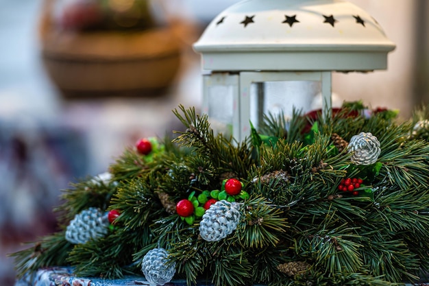 Decorazione festiva con ornamenti di rami di abete e lanterna sul tavolo del mercatino di Natale