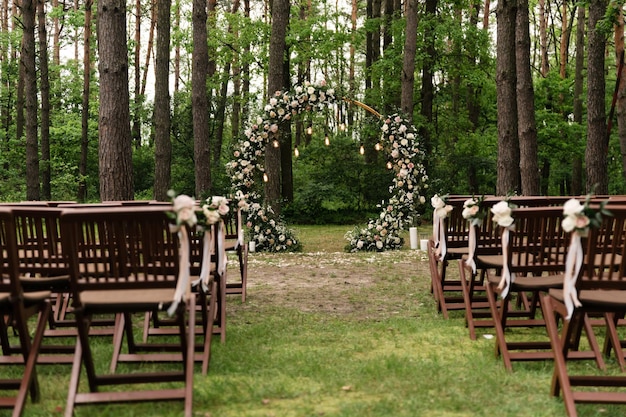 Decorazione fiorita dell'arco nuziale con rose, garofani ed eucalipti. Bella cerimonia di matrimonio all'aperto. Colori bianco e rosa. Zona foto di matrimonio. concetto floreale. Dettagli del matrimonio