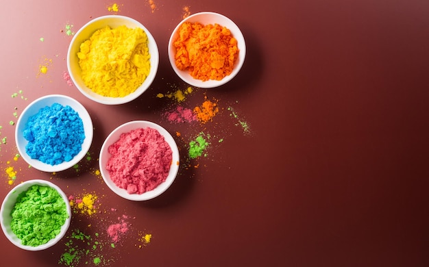 Decorazione Happy Holi la festa indianaVista superiore della polvere Holi colorata sullo sfondo scuro