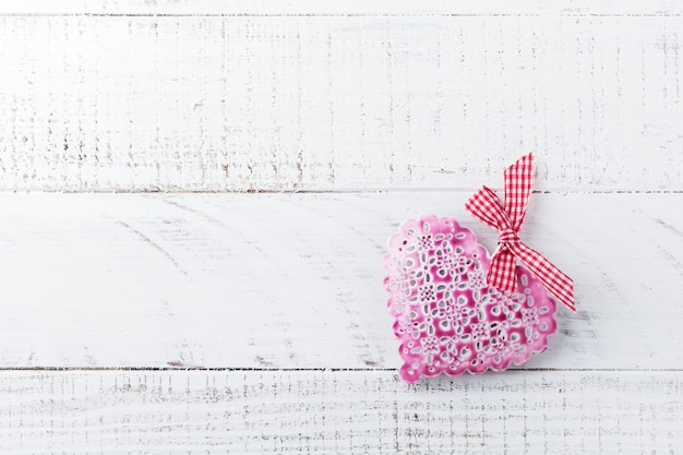 Decorazione in forma di cuore decorativa d'annata su un supporto di legno su fondo bianco