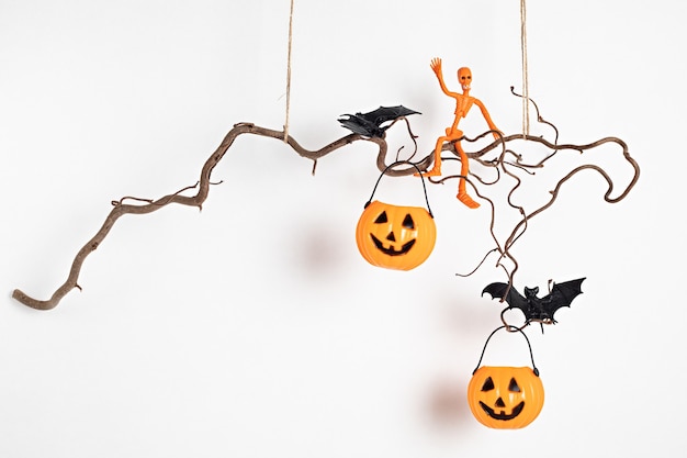 Decorazione minima di Halloween che appende sul ramo di albero isolato