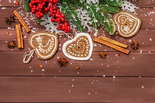 Decorazione natalizia. Abete di Capodanno, foglie fresche, cuori di biscotti allo zenzero all'uncinetto, spezie e neve artificiale.