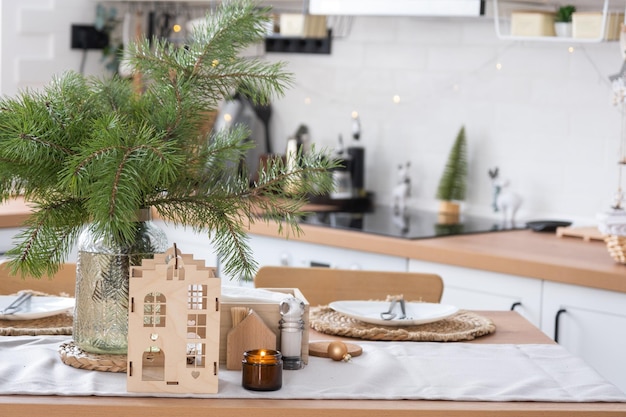 Decorazione natalizia festiva in cucina bianca colazione festiva interno scandi bianco La figura di una casa accogliente ione la tavola apparecchiata umore di Capodanno casa accogliente Copia spazio