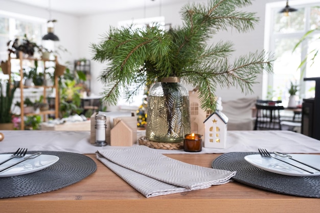 Decorazione natalizia festiva in cucina bianca colazione festiva interno scandi bianco La figura di una casa accogliente ione la tavola apparecchiata umore di Capodanno casa accogliente Copia spazio