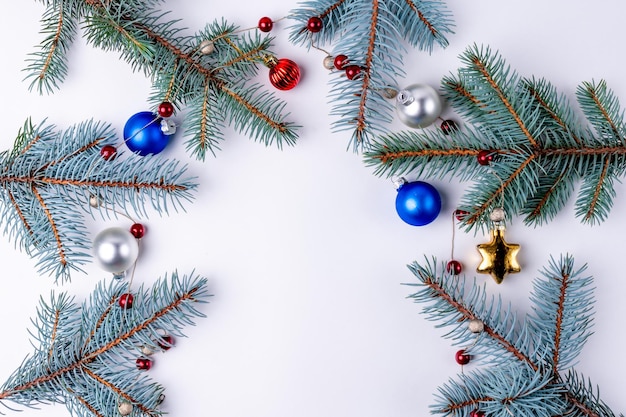 Decorazione natalizia, rami di un albero di Natale su sfondo bianco. Biglietto natalizio.