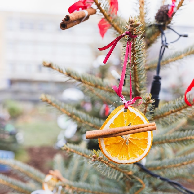 Decorazione naturale fatta a mano fai-da-te con fette d'arancia e spezie sull'albero di Natale