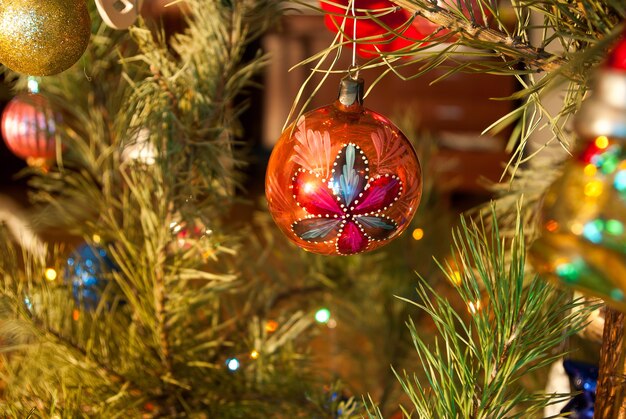 Decorazione per albero di Natale in vetro sullo sfondo di un albero di Natale con luci