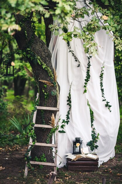 Decorazione per il matrimonio lanterne nere edera ramoscelli canne scale fiori in stoffa bianca su rovere