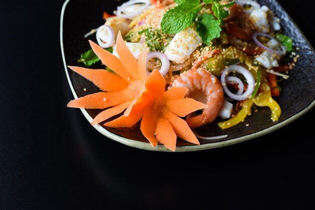 Decorazione per insalata di mare fatta di carota cruda come fiore, creatività