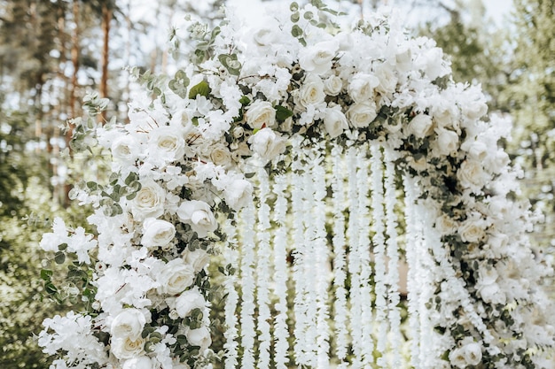 Decorazioni ad arco con fiori bianchi per una cerimonia di matrimonio nella natura