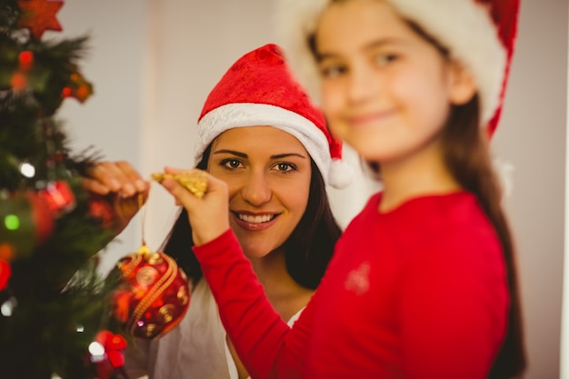 Decorazioni d&#39;attaccatura di natale della figlia e della madre sull&#39;albero