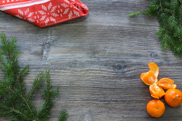 Decorazioni di Capodanno e Natale su una superficie di legno con mandarini e un albero di Natale verde