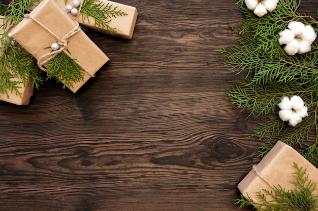 Decorazioni di Natale e scatole regalo sul bordo di legno scuro con spazio di copia