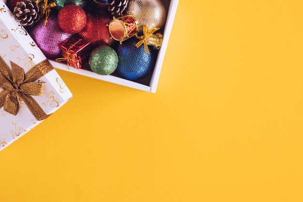 Decorazioni di Natale in confezione regalo su uno sfondo giallo.