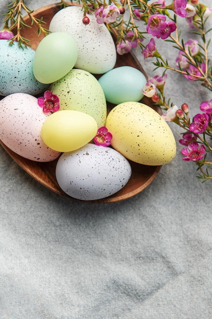 Decorazioni di Pasqua Uova di Pasqua colorate su un piatto di legno sul tavolo