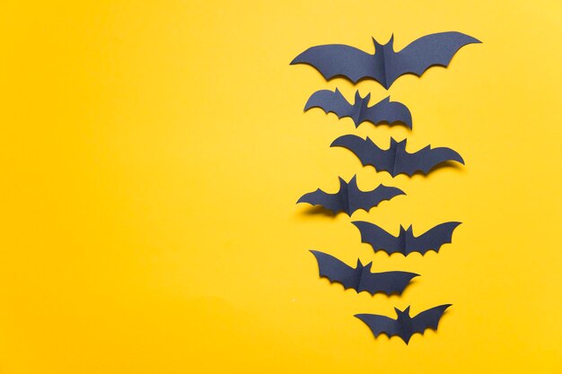 Decorazioni di pipistrello vampiro di carta di Halloween su sfondo arancione