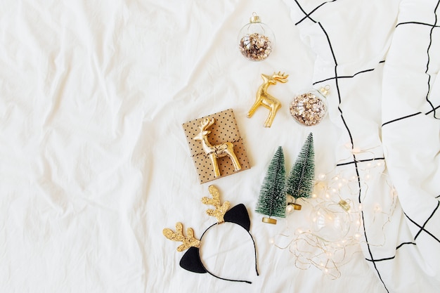 Decorazioni e regali di Natale sul letto bianco con una coperta. Concetto di vacanza. Disposizione piatta, vista dall'alto