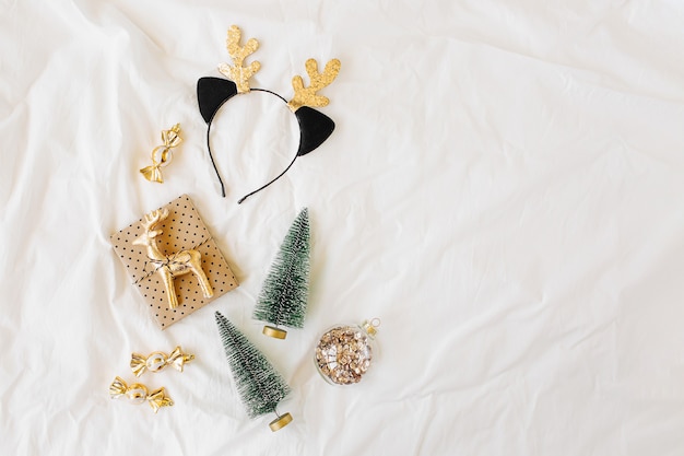 Decorazioni e regalo di Natale sul letto bianco. Concetto di vacanza. Disposizione piatta, vista dall'alto