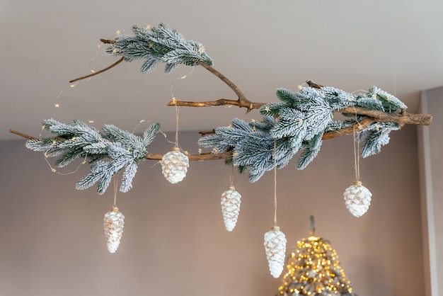 Decorazioni natalizie a soffitto realizzate con rami di abete e giocattoli di Capodanno a forma di pigna. Sfondo di Natale.