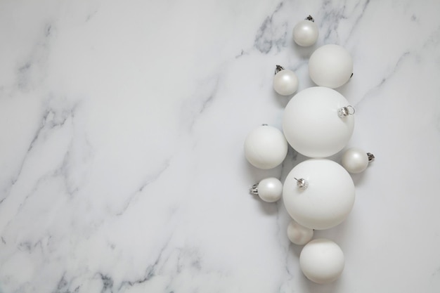 Decorazioni natalizie bianche a forma di palla su uno sfondo di marmo