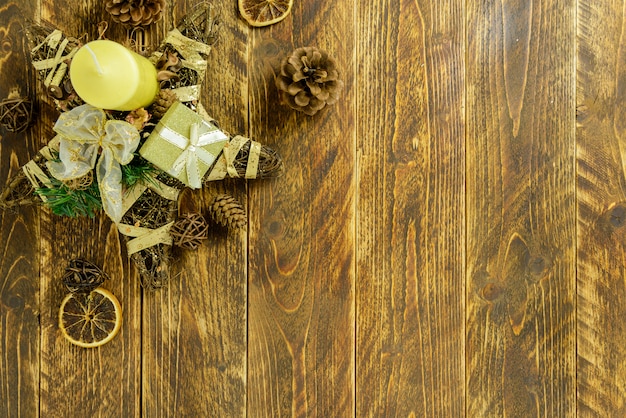 Decorazioni natalizie, candela gialla e pigne su un tavolo di legno marrone. Vista dall'alto, copia spazio.