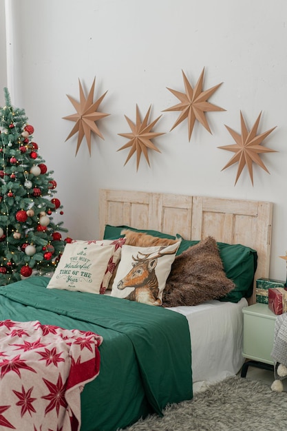 Decorazioni natalizie classiche in camera da letto. Albero di Natale con palline bianche e rosse.