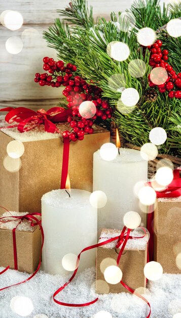 Decorazioni natalizie con candele accese e regali. Immagine dai toni in stile retrò con effetti di luce
