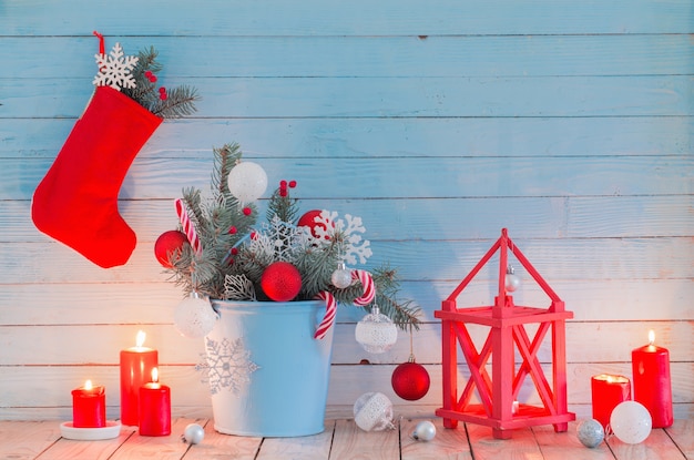 Decorazioni natalizie con candele accese su fondo di legno blu