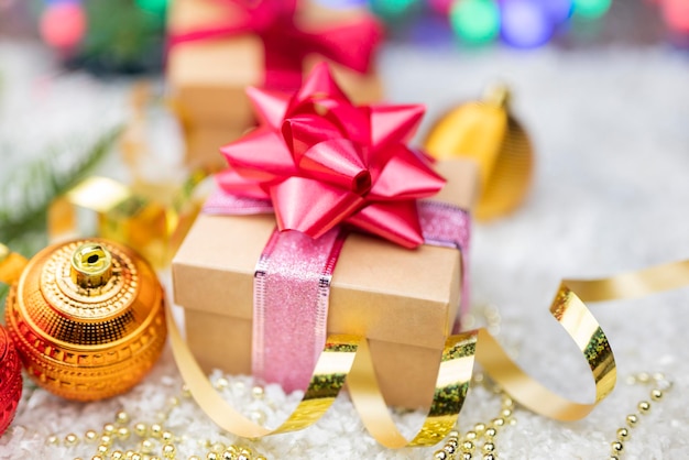 Decorazioni natalizie con palline decorative su albero di Natale con serpentine e scatole regalo