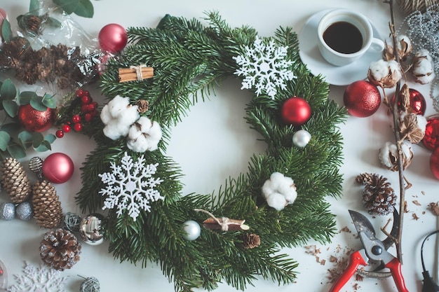 Decorazioni natalizie con palline di Natale rosse, albero sempreverde, coni e fiocco di neve